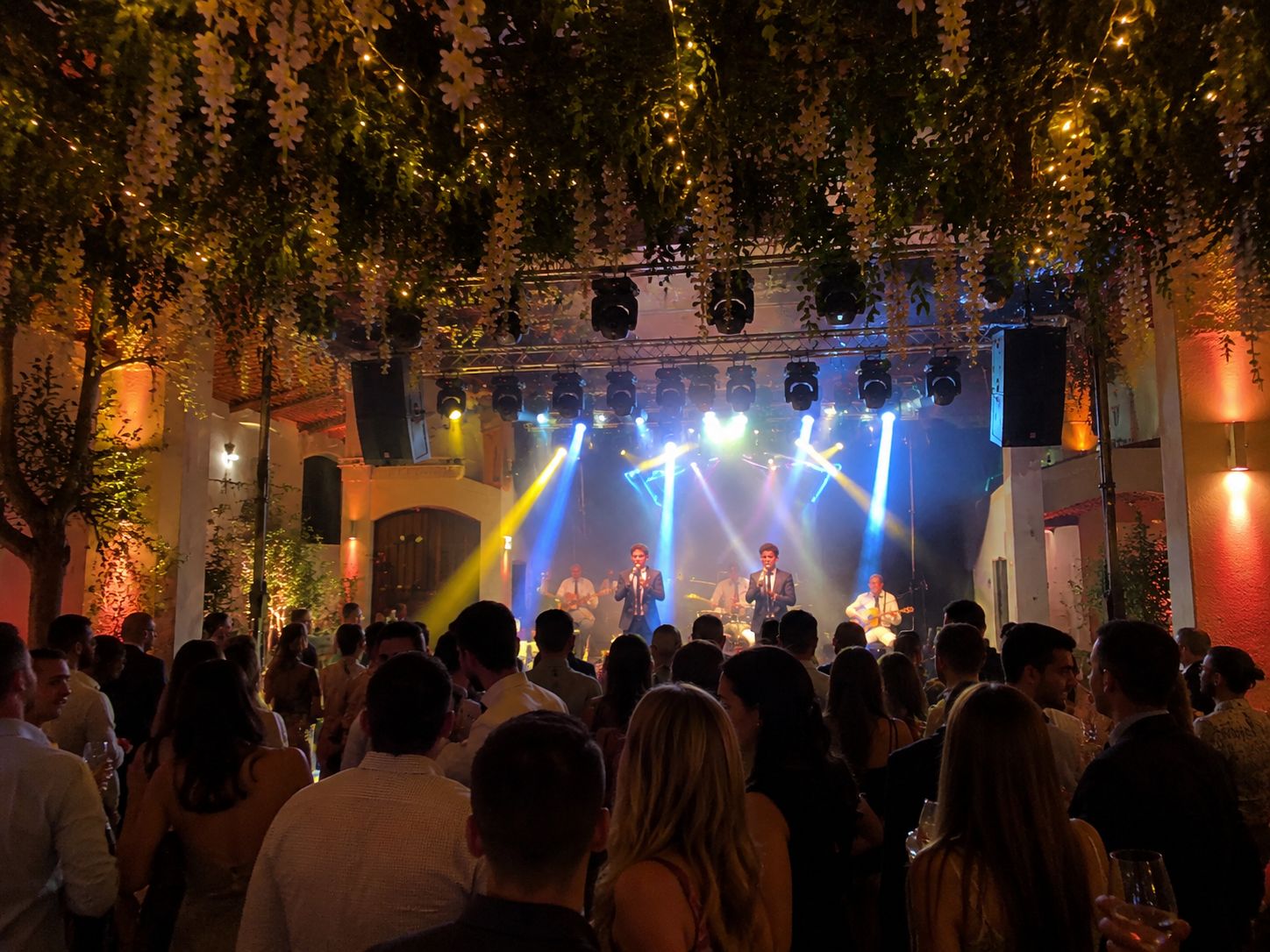 Escenario con cabezas móviles e invitados en una boda en Cádiz